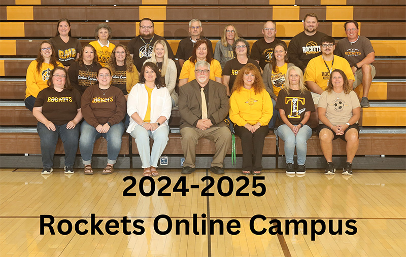 Rockets staff smiling for the camera in front of the school building