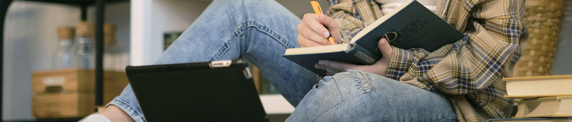 Girl taking notes while watching lesson on her tablet