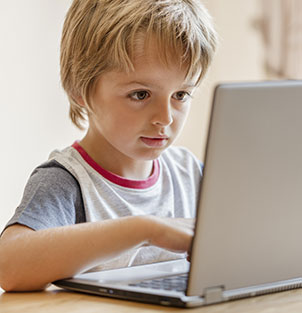 Elementary boy learning on a laptop