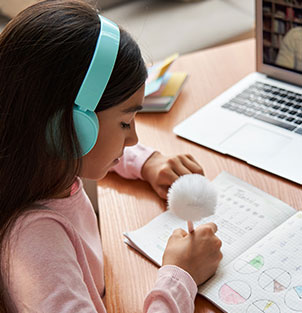 Middle school student taking notes during her virtual lesson